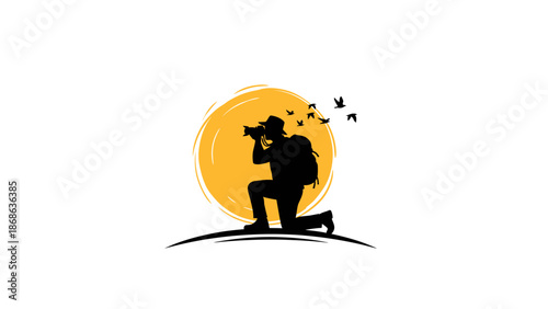 Silhouette of a photographer kneeling and taking a picture.