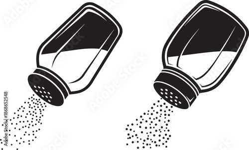Two salt shakers pouring salt on a for food and spice concepts