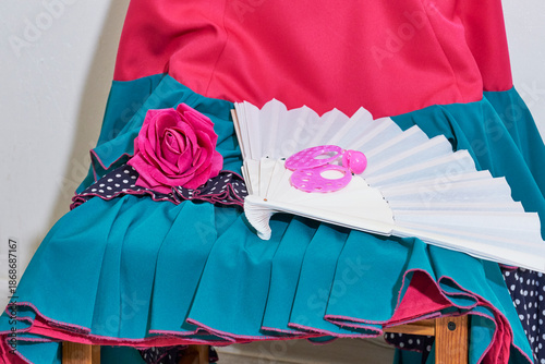 Vivid flamenco dress and accessories: rose, fan, and earrings