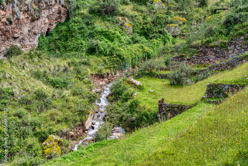 Scenic view with the ancient Inca archaeological complex of Pisac, located on a steep green mountainside in the Peruvian Andes of Peru