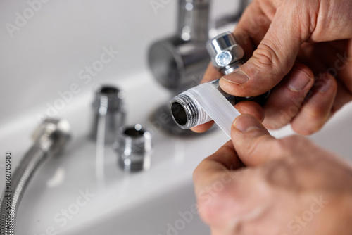 Cuadro en lienzo Plumber apply teflon seal tape on the plumbing fitting thread