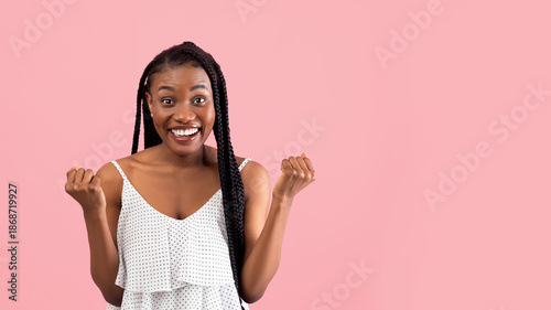 Fotografie Positive black woman with afro bunches making YES gesture, feeling victorious on pink studio background, banner design with copy space