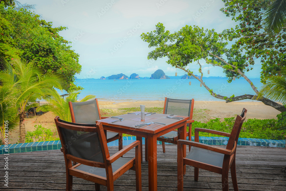 Fototapeta premium Dining table and chairs on the tropical beach island on a summer day