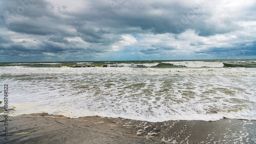 Фотография Stormy beach in Florida with rough waves and empty shoreline