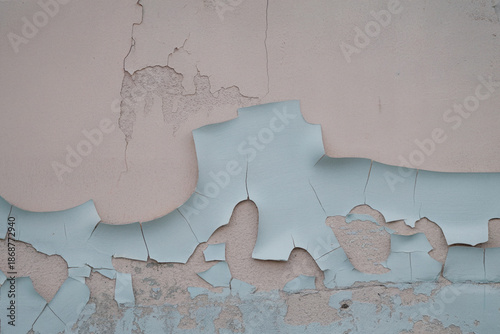 Macro close-up of peeling paint and falling plaster on an old wall surface, showing cracked, rough texture and weathered decay. Ideal for abstract backgrounds, renovation concepts, construction themes