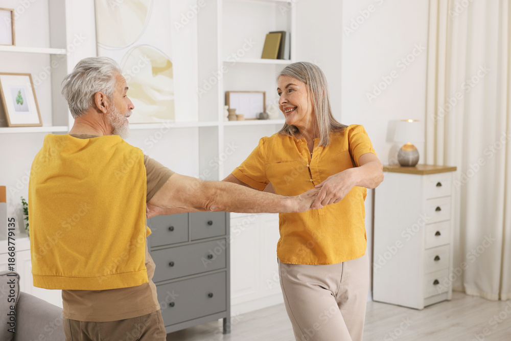 Fototapeta premium Lovely senior couple dancing together at home