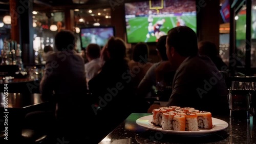 People watch sports while enjoying sushi in a lively restaurant setting. Super Bowl