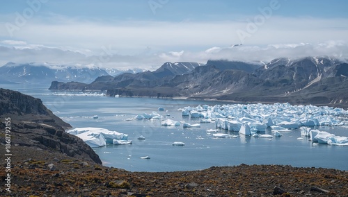 Mountains and Ice Formations Stand Under Cloudy Skies in a Landscape Near a G...