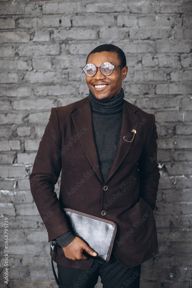Obraz premium Stylish smiling Black businessman in suit and glasses