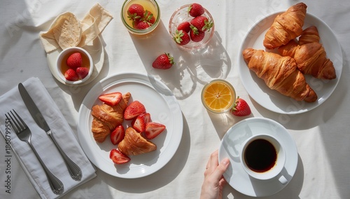 Enjoying a Breakfast Spread With Croissants, Strawberries, and Coffee on a Br...