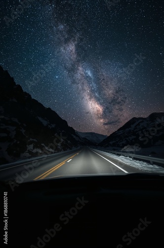 Stars Shine Brightly Over a Winding Road in the Mountains at Night