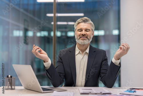 Fotografi Mature businessman finding tranquility and stress relief through meditation at h