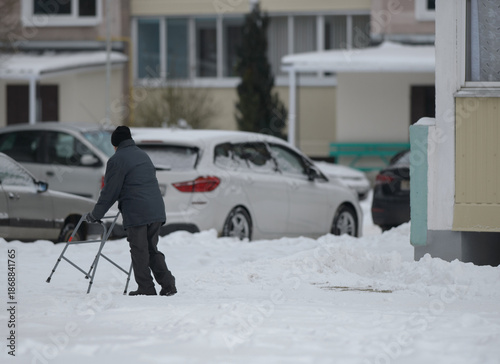 An elderly man walks with the help of stilts
