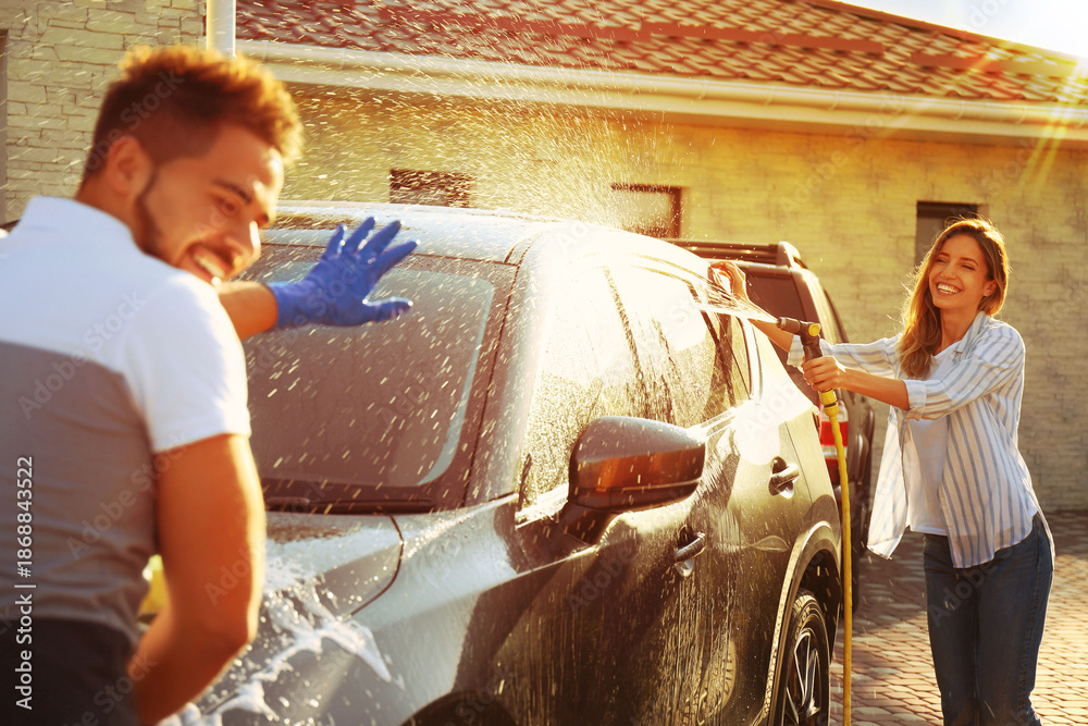 © New Africa - Happy couple washing car and having fun at backyard on sunny day © New Africa - Happy couple washing car and having fun at backyard on sunny day