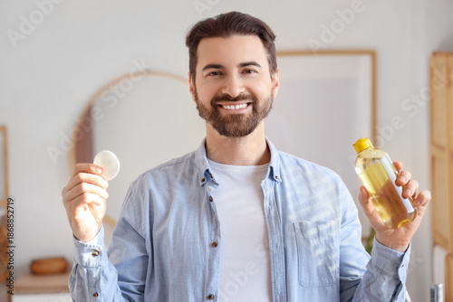 Handsome man with bottle of...