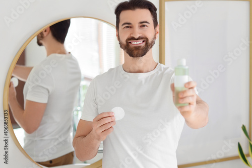 Handsome man with bottle of...