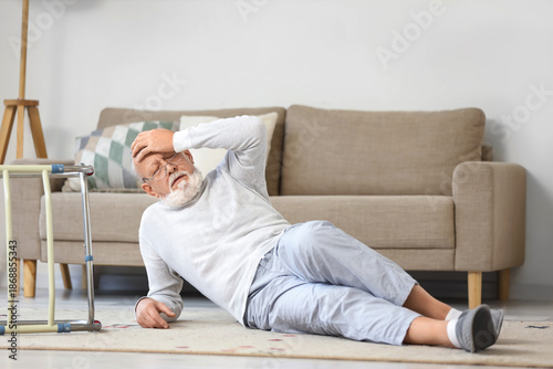 Foto Senior man with walker lying on floor after fall at home