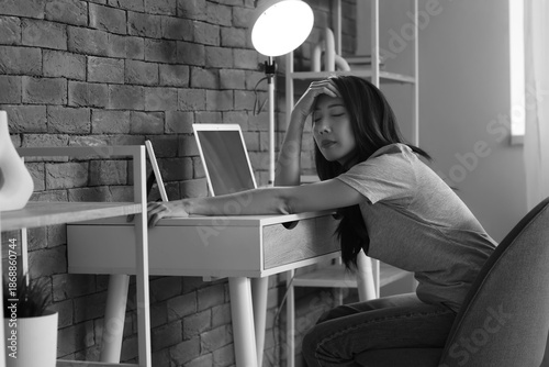 Sad young Asian woman sitti...