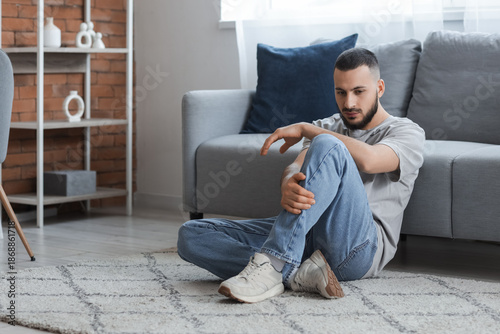 Depressed young man sitting...