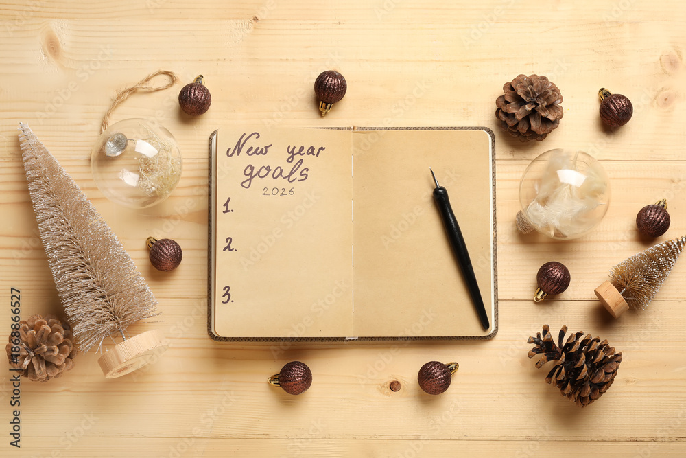 Fototapeta premium Notebook with empty to do list, pen and Christmas decor on wooden background. New Year Goals 2026