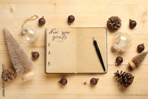 Notebook with empty to do list, pen and Christmas decor on wooden background. New Year Goals 2026