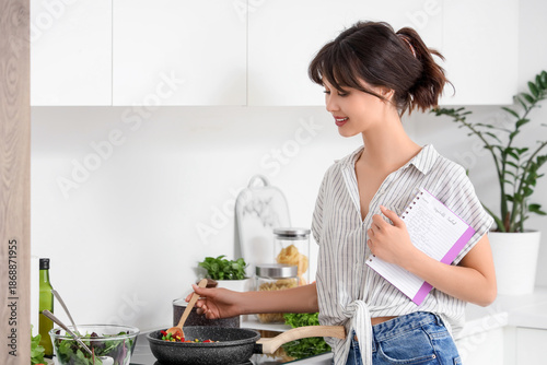 Young woman with recipe boo...