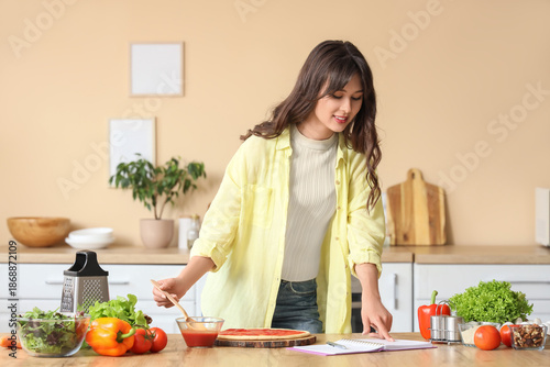 Young woman with recipe boo...