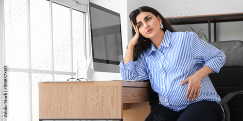 Tired pregnant businesswoma...