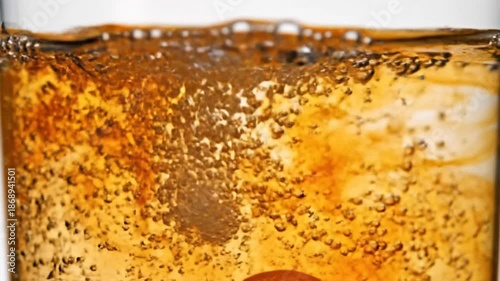 Orange effervescent tablet dropping into clear water, creating splash and bubbles