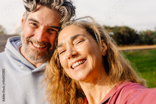 Selfie of a mature couple smiling at the camera dressed in sportswear