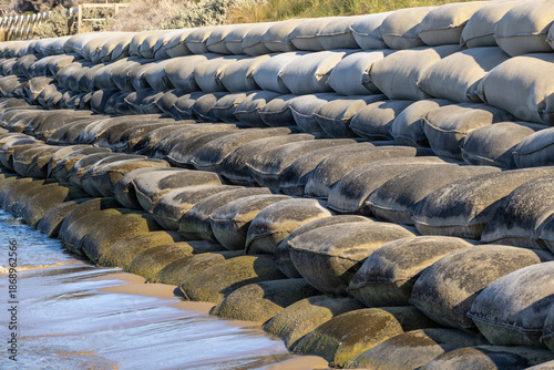 Billede på lærred Stacked sandbags installed along the shoreline at Portsea Beach in Victoria, Australia, forming a coastal protection barrier against erosion and wave impact