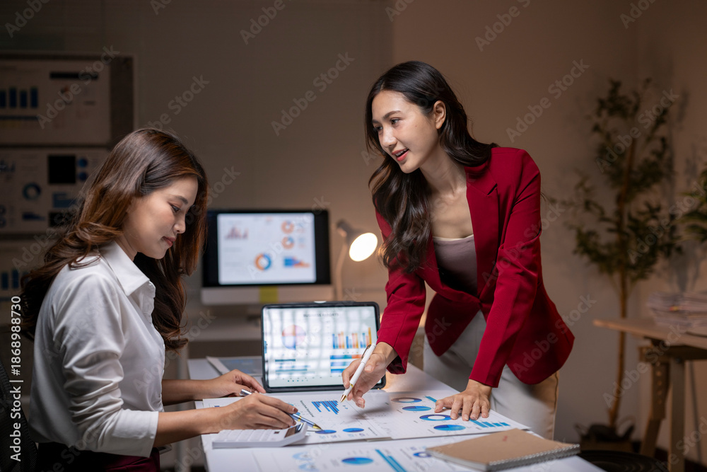 Fototapeta premium Businesswomen collaborating on financial data analysis in office