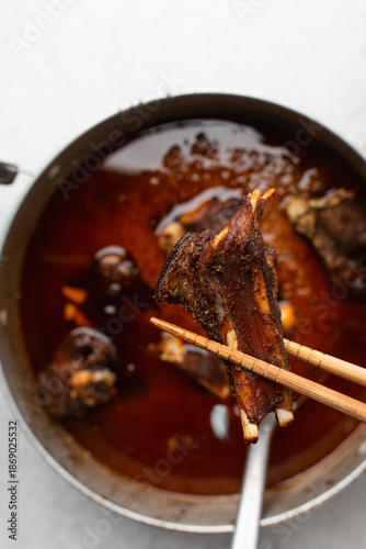 overhead view of fried goat meat in chopsticks, top view of fried mutton