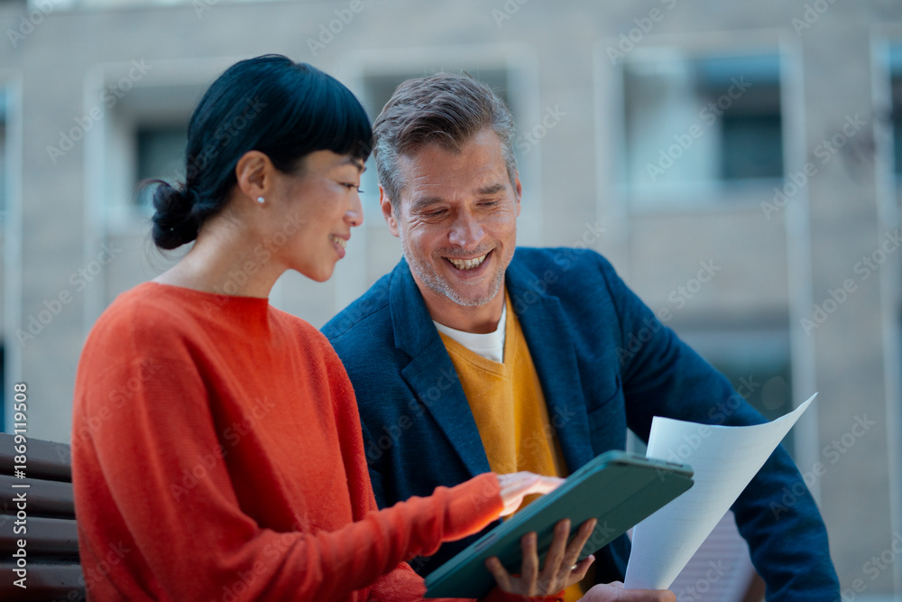 © Artcore Studio/Stocksy - Diverse colleagues discussing business documents outdoors © Artcore Studio/Stocksy - Diverse colleagues discussing business documents outdoors