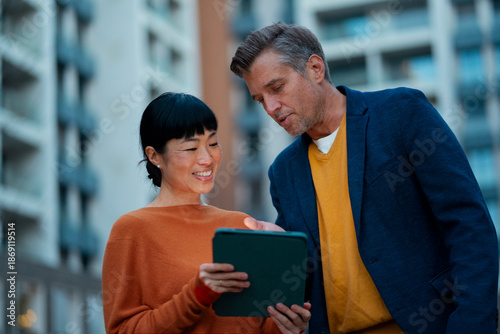 Diverse business colleagues reviewing data on tablet
