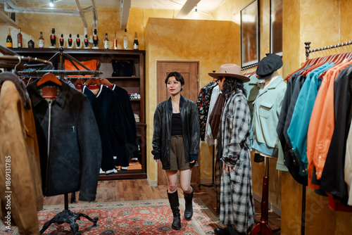 Shop assistant helping female customer in fashion boutique in Japan
