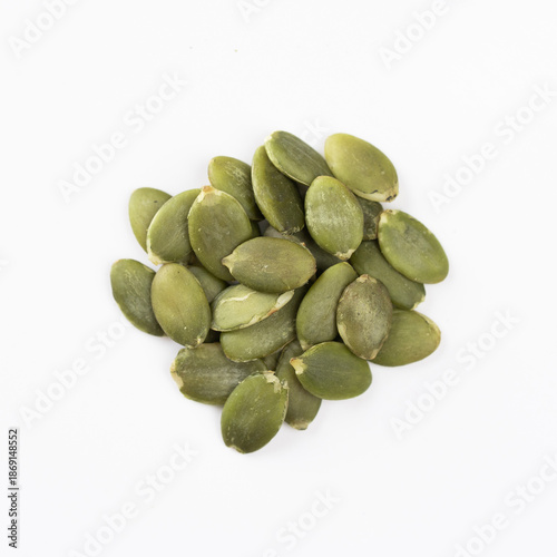 Green Pumpkin seeds closeup placed on a white background.