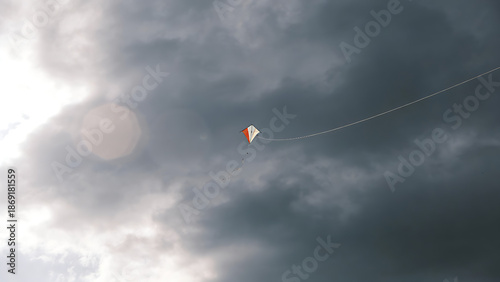 twinge. Broken kite string, kite drifting away in gray overcast sky, minimalist composition. wellbeing guides, coaching materials, designed for mental health education and mindfulness programs.