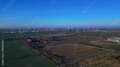 Wallpaper Mural wind turbines generating clean energy, linked to a power substation and high voltage power lines. Unique aerial view drone shot from above Torontodigital.ca