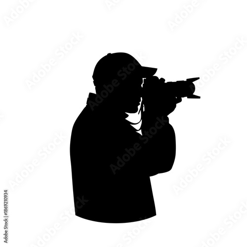 Silhouette of a photographer wearing a cap holding a professional camera and shooting.