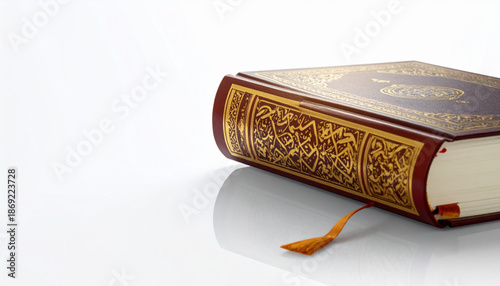 An ornate leather-bound book with golden embellishments lies on a white surface, viewed from above
