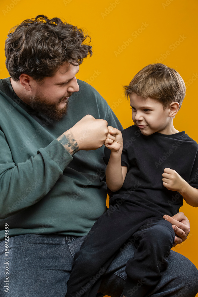 Obraz premium Father Love Concepts. Portrait of Young Funny Smiling Cheerful Playing Parent Dad with Boy Child In Casual Clothing With Lifted Hands Hugging Cuddle Looking Side Isolated