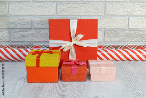Colorful wrapped gifts are arranged neatly on a table with festive background during holiday season in indoor setting