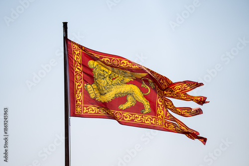 Flag of the Republic of Venice with the winged Lion of Saint Mark waving against a clear blue sky.