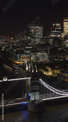 Vertical aerial view of London skyline at night. Beautiful view of Tower Bridge and the City of London illuminated by city lights