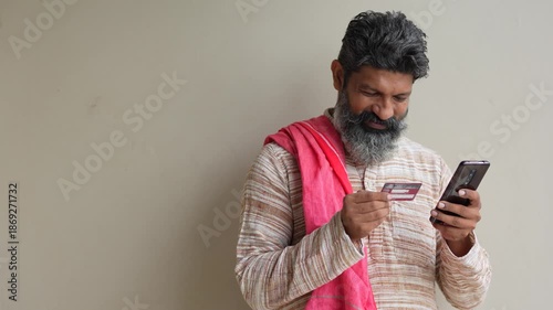 indian farmer using smartphone and card 
