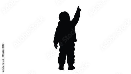 A child pointing upwards viewed as a dark form silhouette