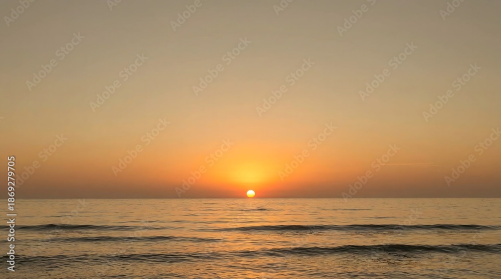 Fototapeta premium Minimalist ocean sunset with warm golden colors and gentle waves, creating a relaxing and peaceful seascape background.Keywords