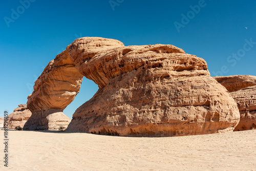 Desert Rainbow Arch (in Saudi Arabia) rock arch under clear sky: impressive sandstone formation in a remote landscape