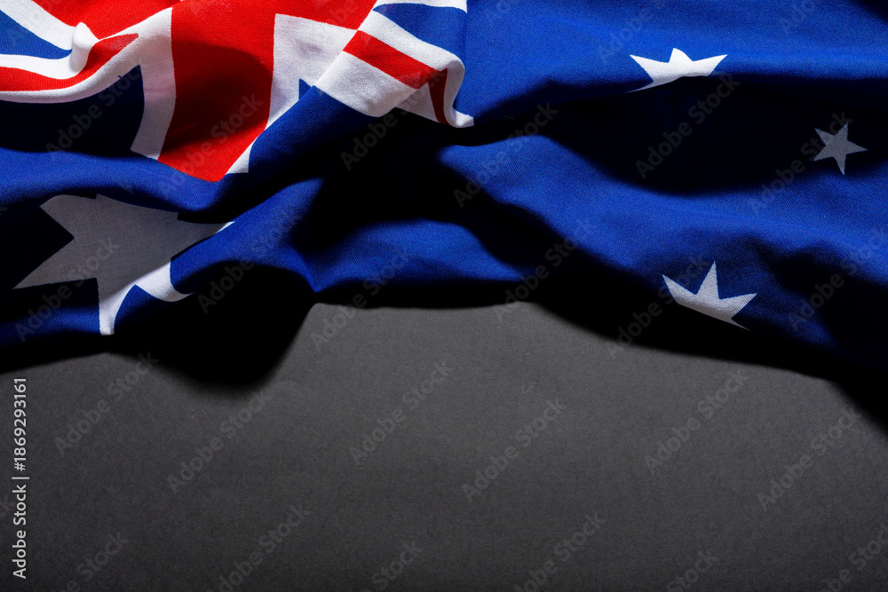 Fototapeta premium British union jack along with stars on australia flag on black table and copy space